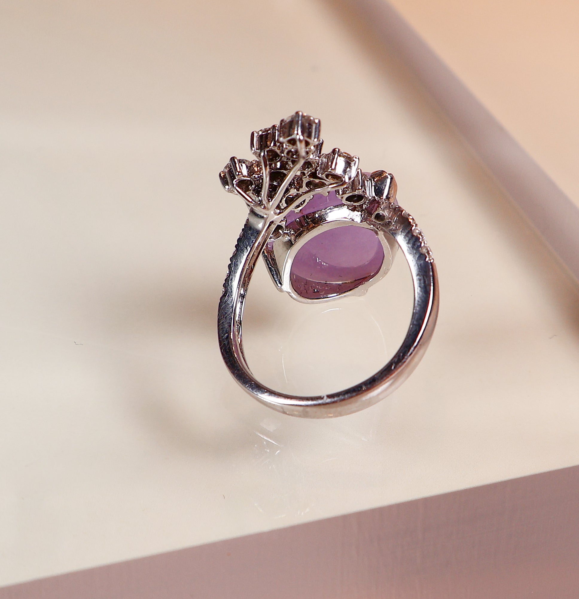 A uniquely shaped purple jade and a uniquely designed ring with multiple diamonds